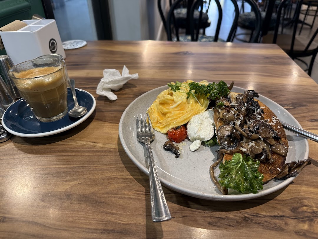 Breakfast plate with coffee on a timber table inside La Grava