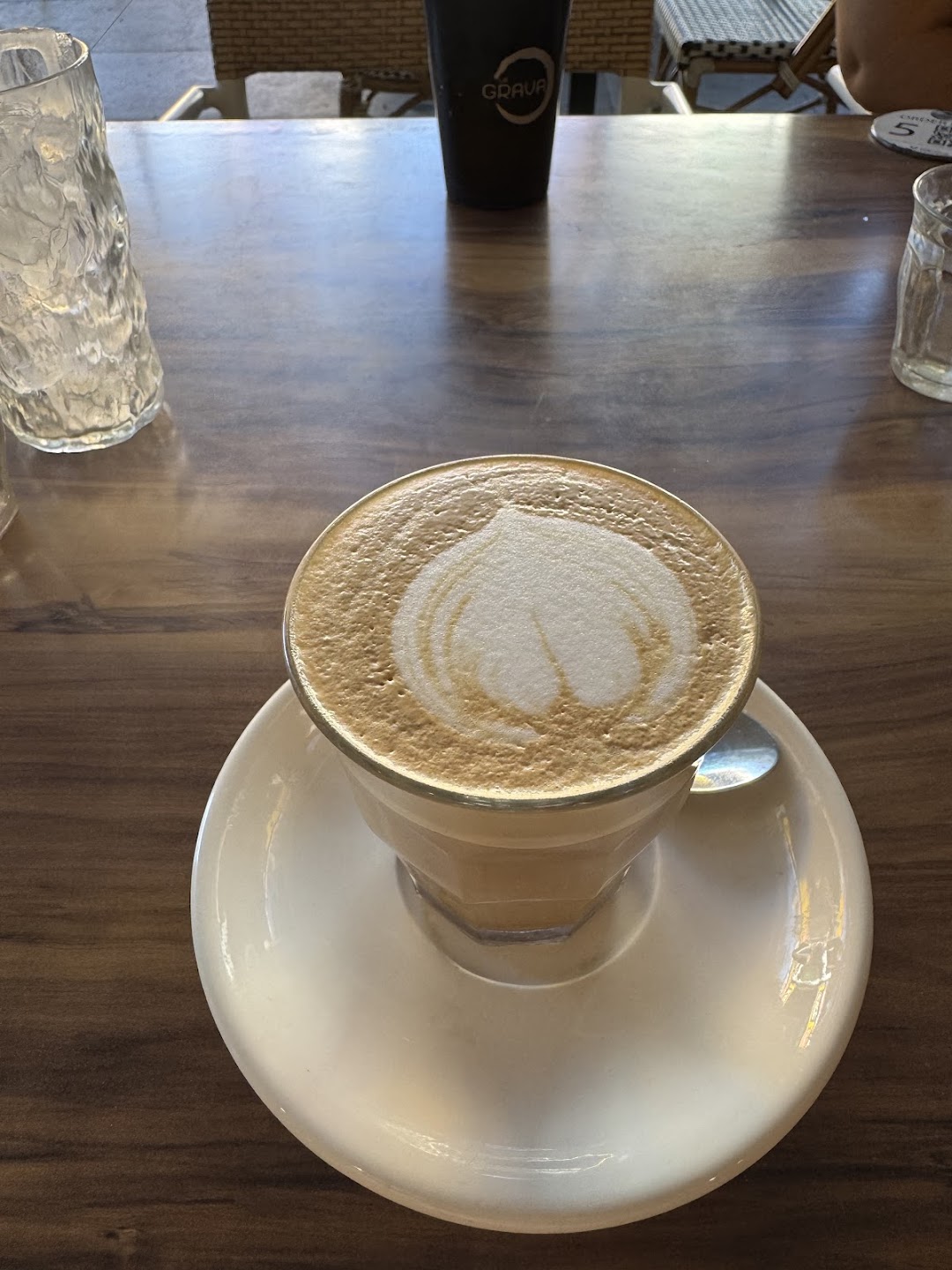 Latte served on a white saucer at La Grava